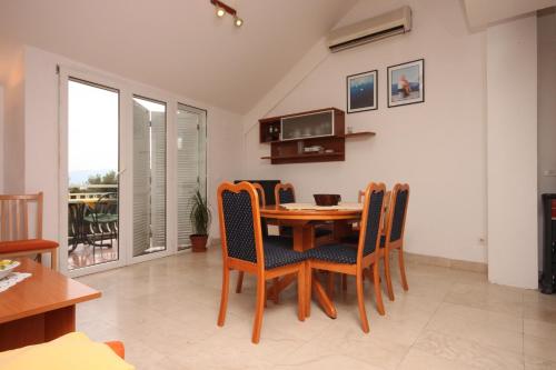 a dining room with a table and chairs at Apartments by the sea Drvenik Donja vala, Makarska - 6658 in Drvenik