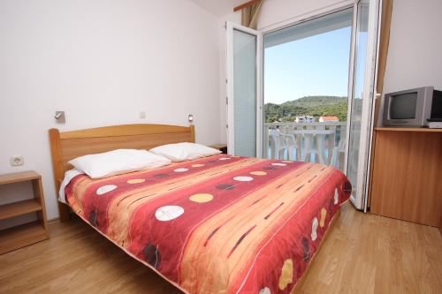 a bedroom with a bed and a sliding glass door at Double Room Zaglav 8144c in Zaglav