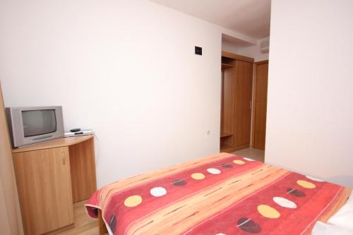 a bedroom with a bed and a tv in it at Double Room Zaglav 8144c in Zaglav