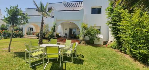 a table and chairs in the yard of a house at La Vida Villa Alcudia Smir Fnideq, Holiday Homes in Tetouan