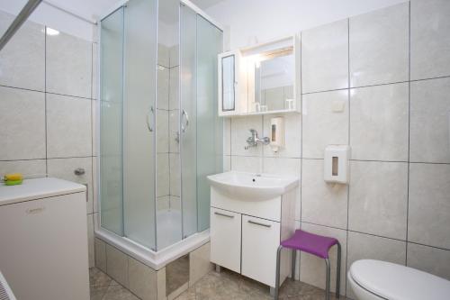 uma casa de banho com um chuveiro, um lavatório e um WC. em Double Room Hvar 8785a em Hvar