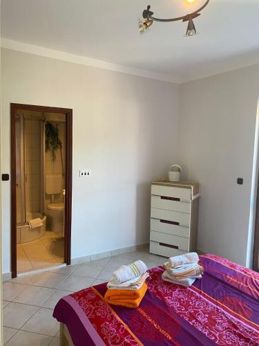 a bedroom with a bed and a dresser and a bathroom at Strandhaus Roko in Preko