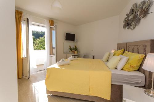 Un dormitorio con una cama amarilla y una ventana en Rooms by the sea Hvar - 8785, en Hvar