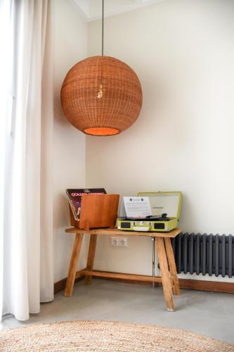 a room with a table with a laptop and a lamp at Van Heeckeren Apartments & Suites Nes in Nes