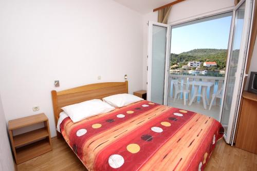 a bedroom with a large bed and a balcony at Double Room Zaglav 8144e in Zaglav