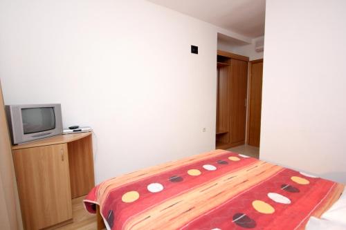 a bedroom with a bed and a tv in it at Double Room Zaglav 8144e in Zaglav