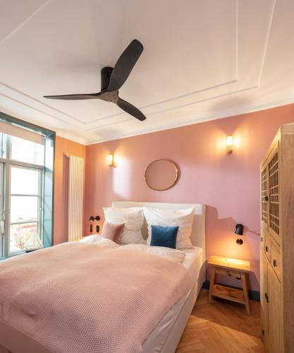 a bedroom with a bed with a ceiling fan at Kapitaenshaus in Wasserlage! Traumapartments Warnemuende in Warnemünde