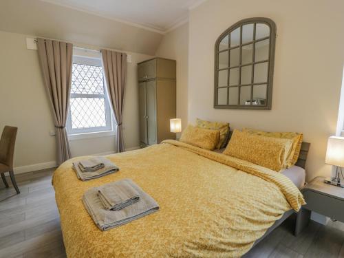 una camera da letto con un grande letto con due asciugamani di 1 Syme Street a Moffat