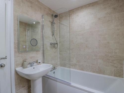 a bathroom with a sink and a tub and a shower at 1 Syme Street in Moffat