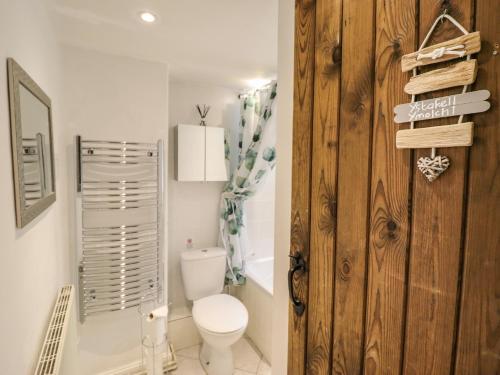 a bathroom with a toilet and a wooden door at Minafon in Oswestry