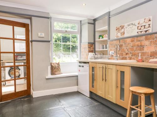 a kitchen with a counter and a sink and a window at Roanview Cottage in Askam in Furness