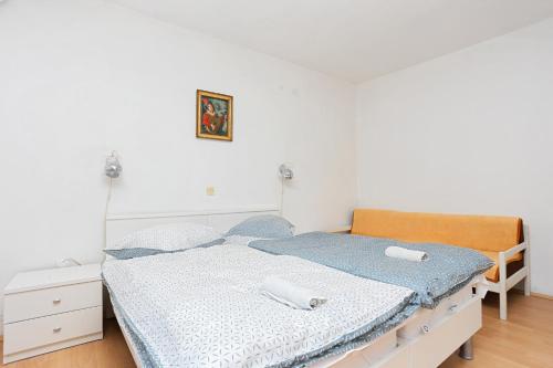 a bedroom with a bed with blue and white sheets at Apartment Tucepi 2676b in Tučepi
