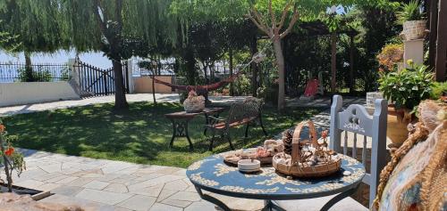 a patio with a table and a swing in a yard at Pelion Platanidia seaside house in Platanidia