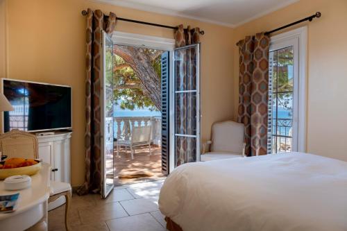 a bedroom with a bed and a sliding glass door at Hôtel Les Mouettes - Teritoria in Ajaccio