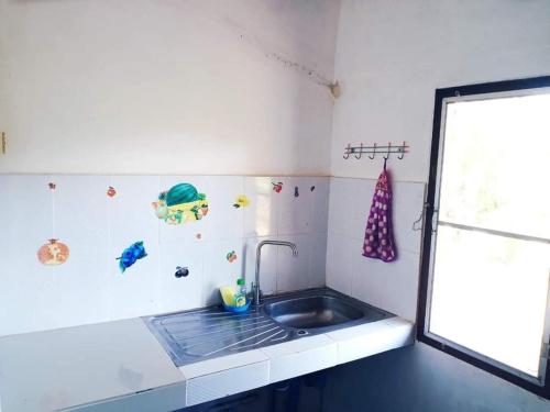 uma pequena cozinha com um lavatório e uma janela em Wandee Resort Bankrut em Ban Krut