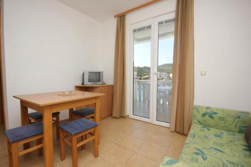 sala de estar con mesa, sillas y TV en Apartments and rooms by the sea Zaglav, Dugi otok - 8144, en Sali