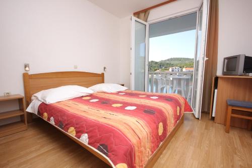 um quarto com uma cama grande e uma varanda em Apartments and rooms by the sea Zaglav, Dugi otok - 8144 em Sali