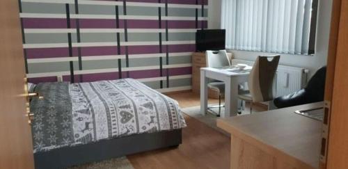 1 dormitorio con 1 cama y escritorio con escritorio en Apartments with a parking space Osijek, Slavonija - 16319, en Osijek