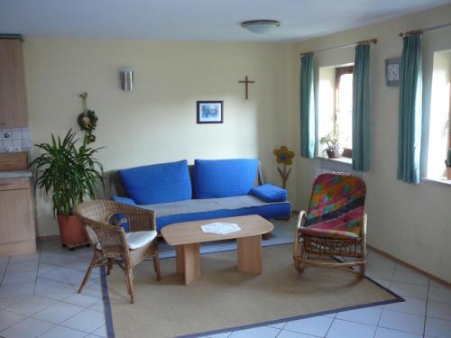 een woonkamer met een blauwe bank en stoelen bij Top Ferienhaus - Nähe Nürnberg - WLAN Free in Neuendettelsau