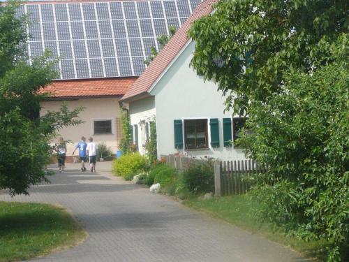 a group of people walking past a house with solar panels at Top Ferienhaus - Nähe Nürnberg - Schnelles Wlan in Neuendettelsau