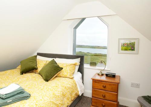 um quarto com uma cama e uma janela em Stripe Bay em Belmullet