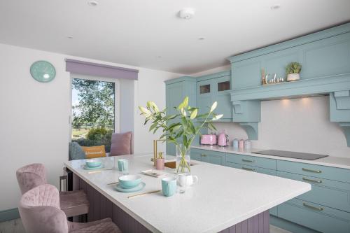 a kitchen with blue cabinets and a white counter top at Curragh House in Kinsale