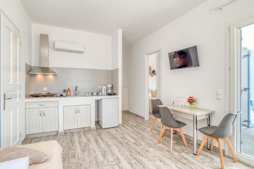 - une cuisine et une salle à manger avec une table et des chaises dans l'établissement Ippocampos Seaside Serenity - Unwind at Paros Poolside Retreats, à Aliki