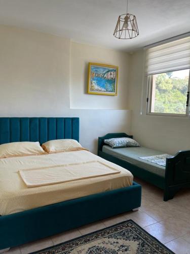 una camera da letto con un letto blu e una finestra di Lisus Apartment a Vlorë