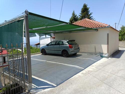 a car parked in a garage with a green awning at Mikros Paradisos Pelion in Áyios Vlásios