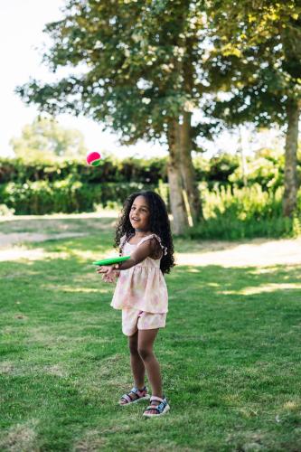 a little girl playing with a frisbee in the grass at Stayokay Hostel Noordwijk in Noordwijk