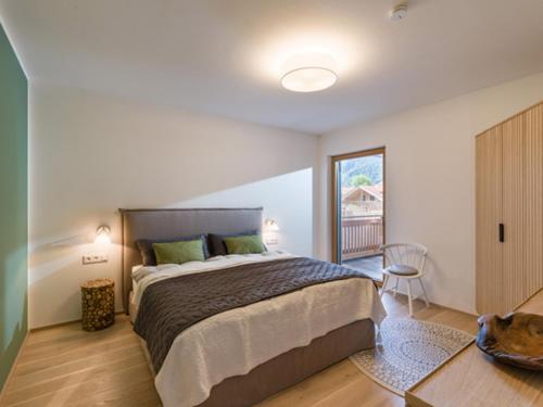 a bedroom with a large bed and a balcony at Apartment Hideaway - Stylisch, ruhig, Topausstattung, Infrarotsauna, Dachterrasse in Walchsee