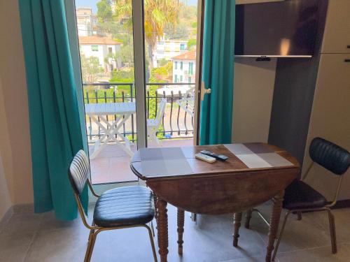 einen Tisch und Stühle in einem Zimmer mit Balkon in der Unterkunft Appartamento Due in Diano Marina