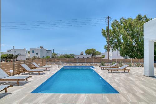 een zwembad met ligstoelen en een zwembad bij Ippocampos Seaside Serenity - Unwind at Paros Poolside Retreats in Aliki
