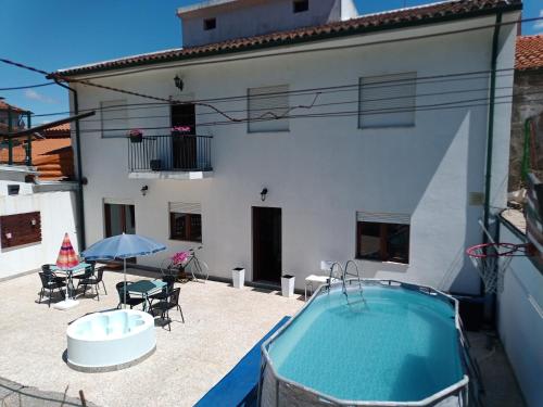 a patio with a swimming pool and a house at Alojamento local Angel`s in Ponte da Barca