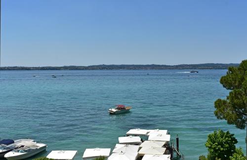 un grupo de barcos en un gran cuerpo de agua en Hotel Pace, en Sirmione