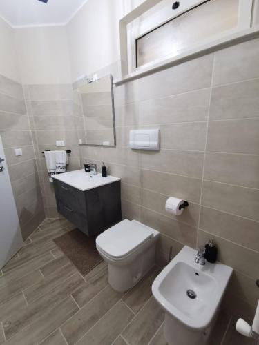 a bathroom with a toilet and a sink and a mirror at Il Piacere in Pineto