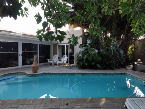 a swimming pool in a backyard with a tree at Mulberry Gardens Self Catering in Swakopmund