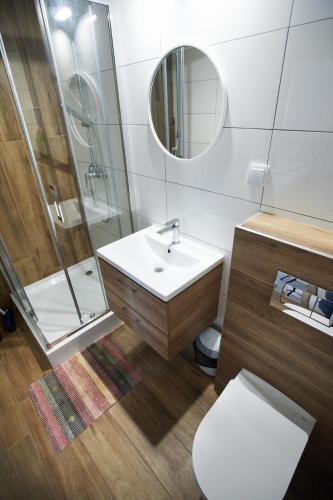 a bathroom with a sink and a shower and a toilet at Wiking in Kretowiny