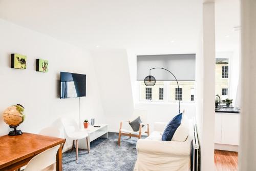a living room with white furniture and a table at Fettes Hideaway in Edinburgh