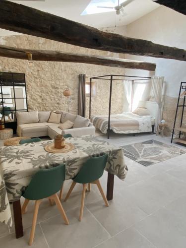 a living room with a table and a bed at Bonnieux : Loft - La pause in Bonnieux