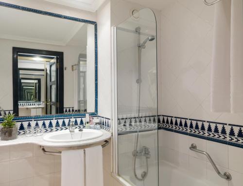 a bathroom with a sink and a shower and a mirror at H10 Tenerife Playa in Puerto de la Cruz