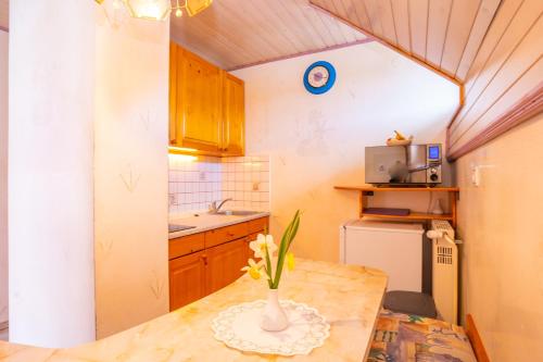 a kitchen with a table with a vase of flowers on it at Apartments Bohinj Mavrica in Bohinj