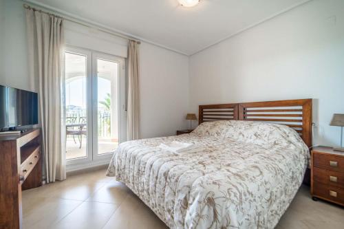 a bedroom with a bed and a television and a balcony at Lovely Apartment with Wrap Around Terrace Golf Views - AO1713LT in Torre-Pacheco