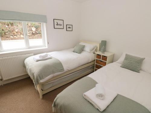 Un dormitorio con dos camas y una ventana. en Trem Y Morfa, en Newport