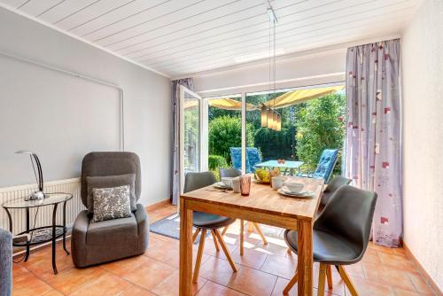 a dining room with a table and chairs and a window at Bungalow Jonas in Trassenheide