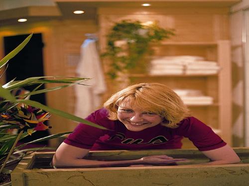 a woman laying in a bathtub in a room at Kurhotel Eichwaldeck in Bad Wörishofen