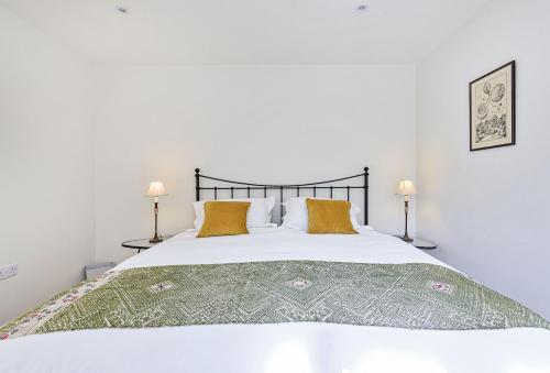 a bedroom with a large white bed with two lamps at La Rose in Gillingham