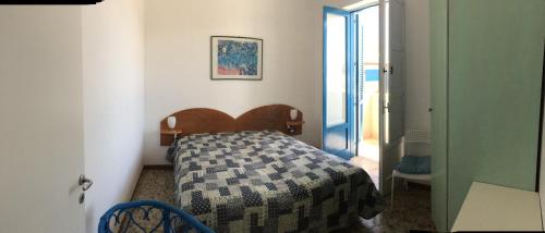 a bedroom with a bed in a room with a door at OSTUNIRESIDENCE baia camerini in Villanova di Ostuni