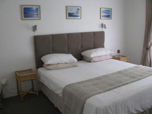 a bedroom with a large bed with two pillows at Sounds of the Sea in East London