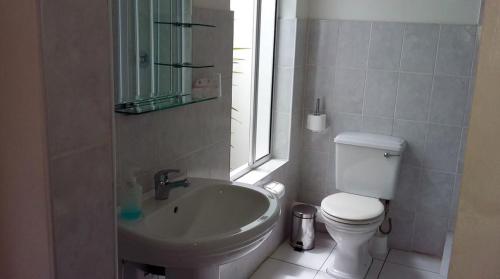 a bathroom with a sink and a toilet and a window at Sounds of the Sea in East London